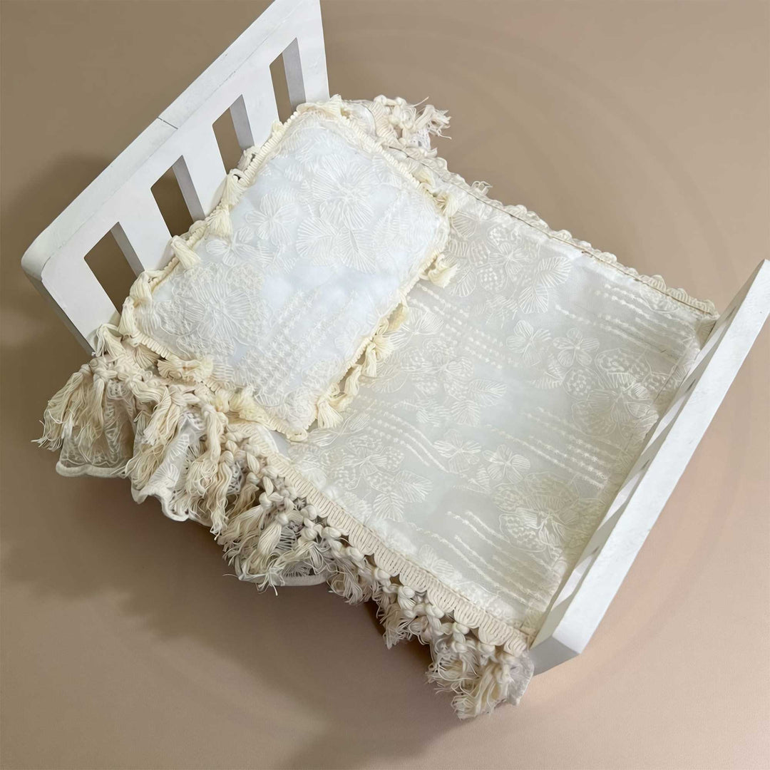 A 2-piece set featuring a newborn blanket and pillow with beige floral embroidery, and tassel trim for newborn photography props.