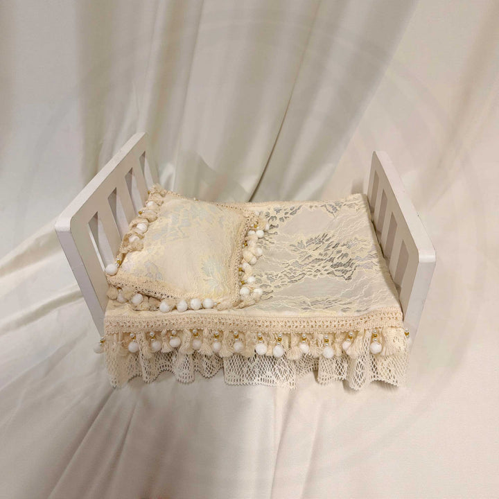 A 2-piece set featuring a newborn blanket and pillow with vintage pearl trim, lace details, and ruffled edges, for newborn photography props.