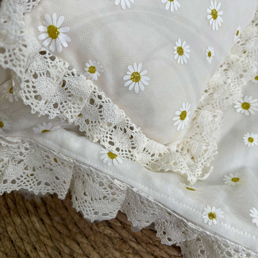 A close-up view of an ivory chiffon featuring ruffled edges and lace trim.