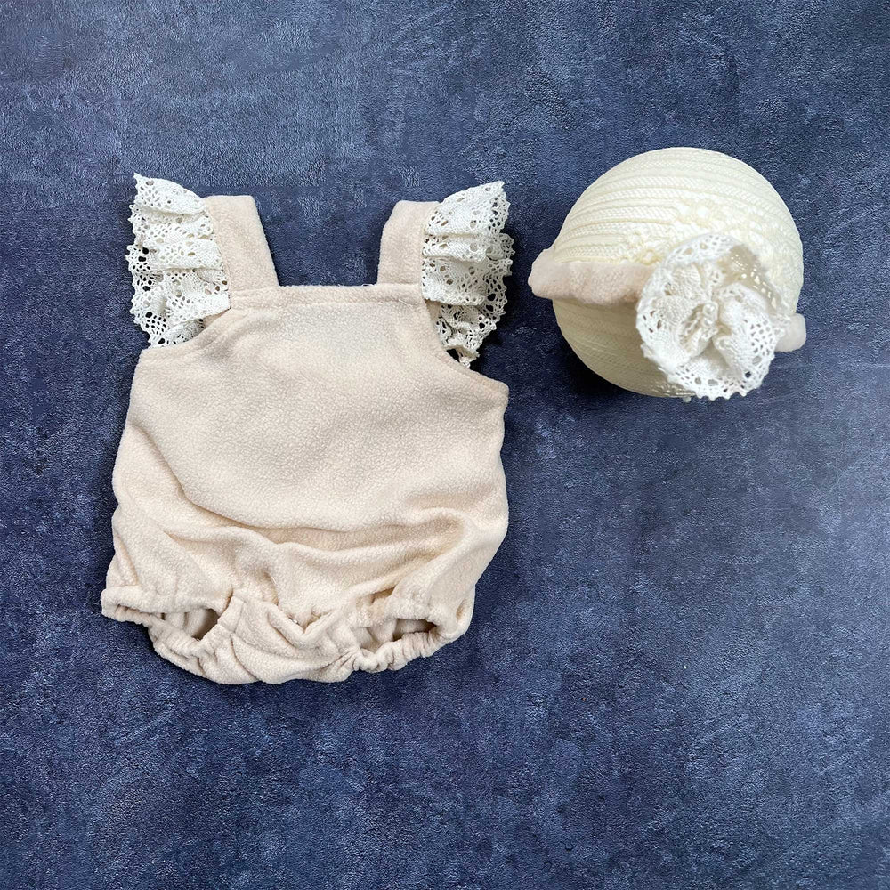 The flat lay shows a polar fleece romper with lace ruffle sleeves and a headband with flower.