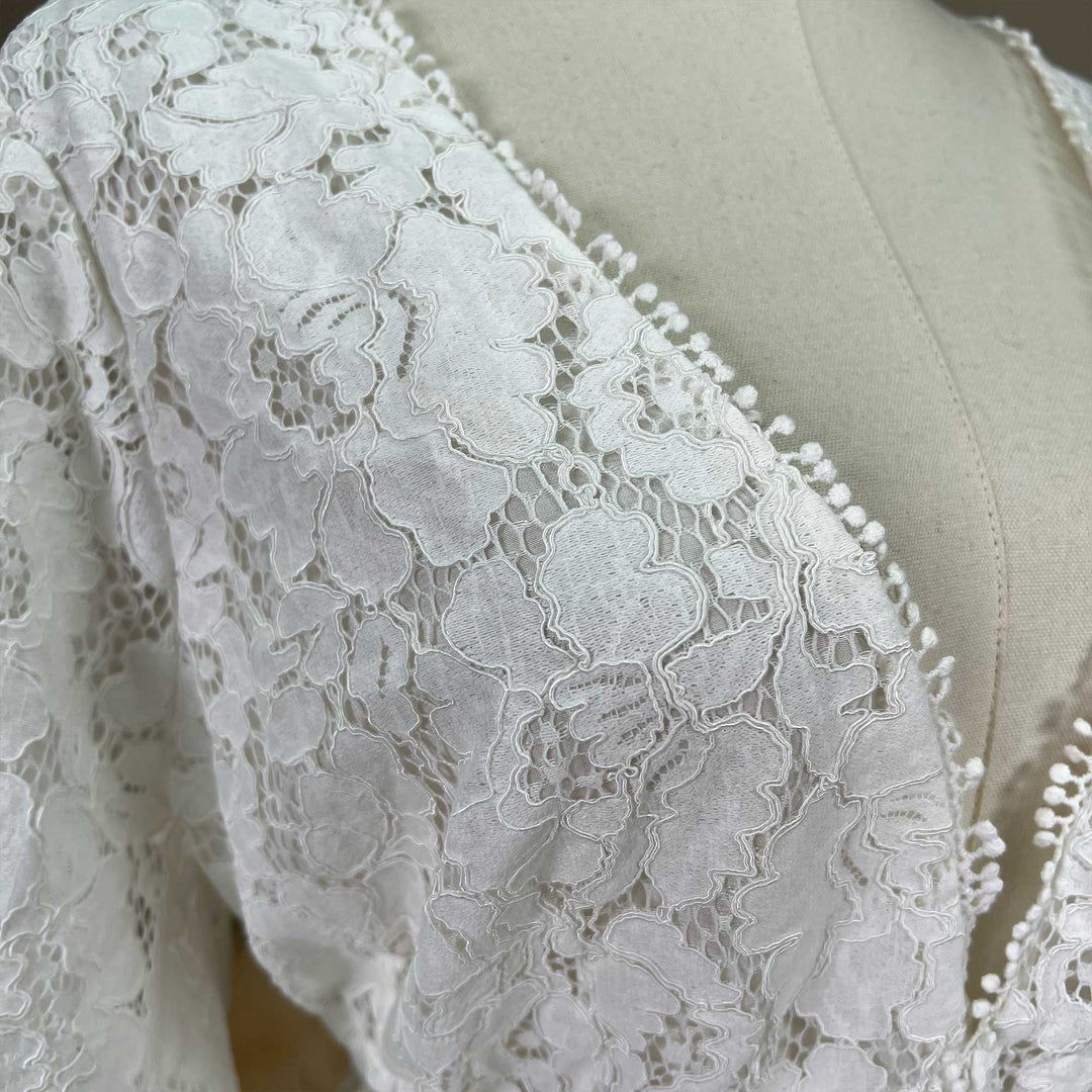 A close-up of ivory lace fabric details.