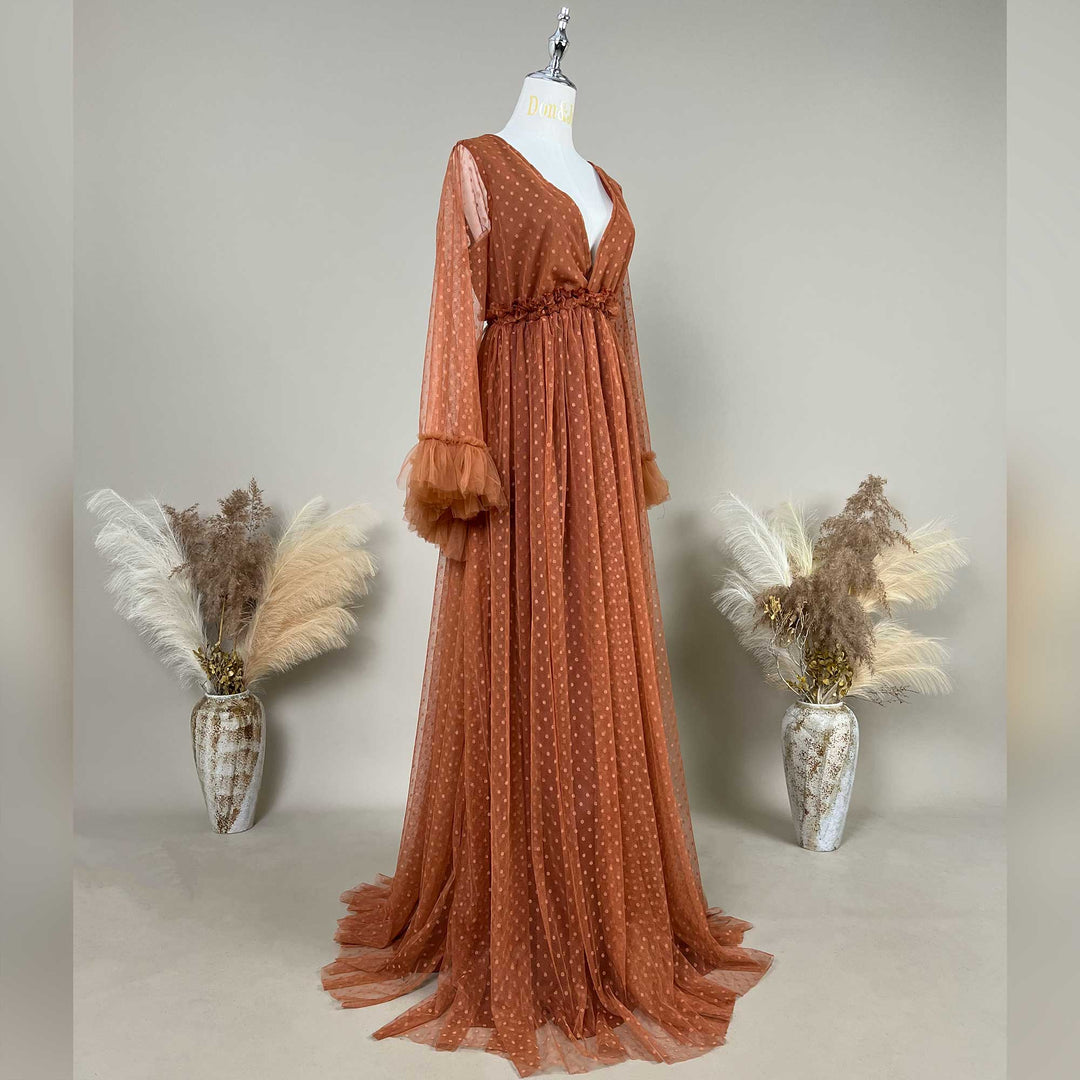 A Terracotta, Alectrona dress with polka dot tulle is displayed on a mannequin against a neutral gray background.