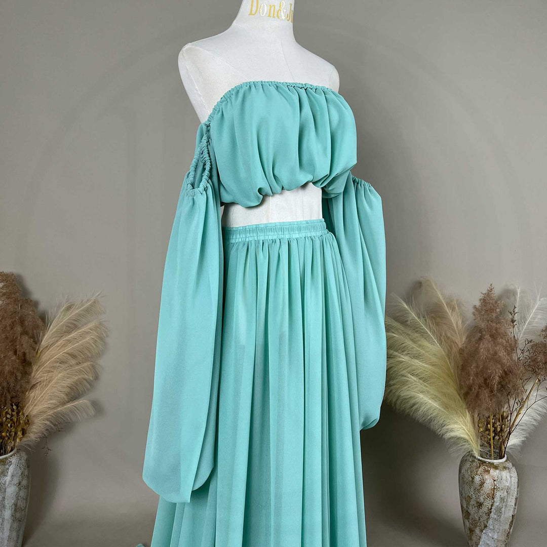 A gaia mint flowy chiffon off-shoulder maternity top with long sleeves displayed on a mannequin.