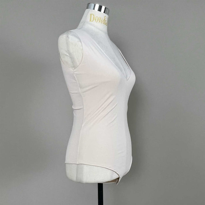 A mannequin shows a side view of a skin sleeveless bodysuit, revealing the V-neck silhouette and fitted cut; the hem features a curved high-cut design
