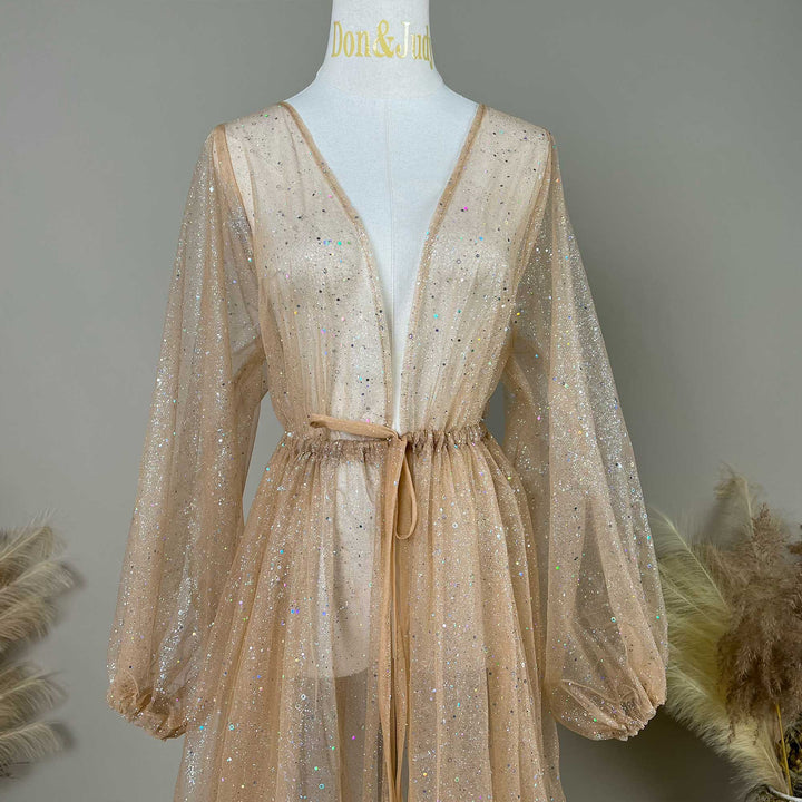 A mannequin displays the upper body of a khaki sequined V-neck robe with a tie waist and lantern sleeves; the fabric is transparent tulle.