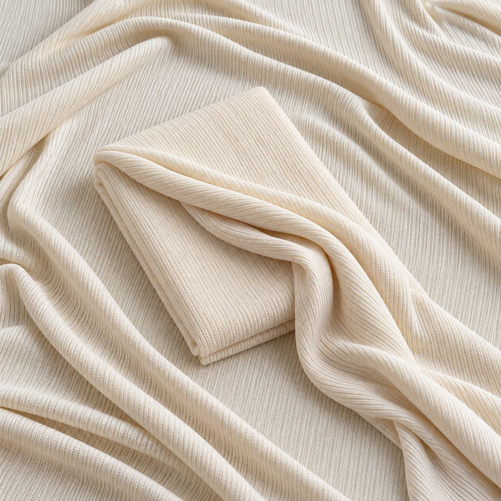 A beige ribbed knit fabric fills the frame, with a folded piece of the same fabric in the middle.