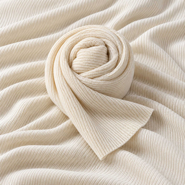 A beige ribbed knit fabric fills the frame, with a strip of the same fabric rolled into a spiral at the center.