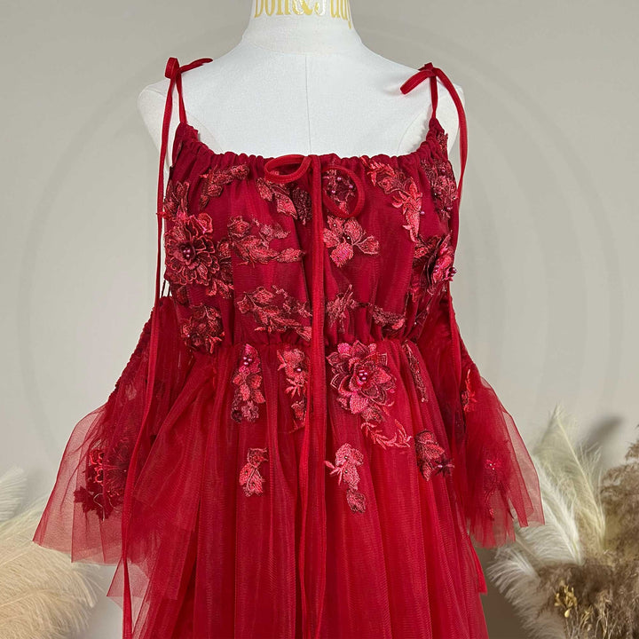 Close-up detail of a Oreades red floral embroidered off-shoulder tiered ruffle maternity photography dress.