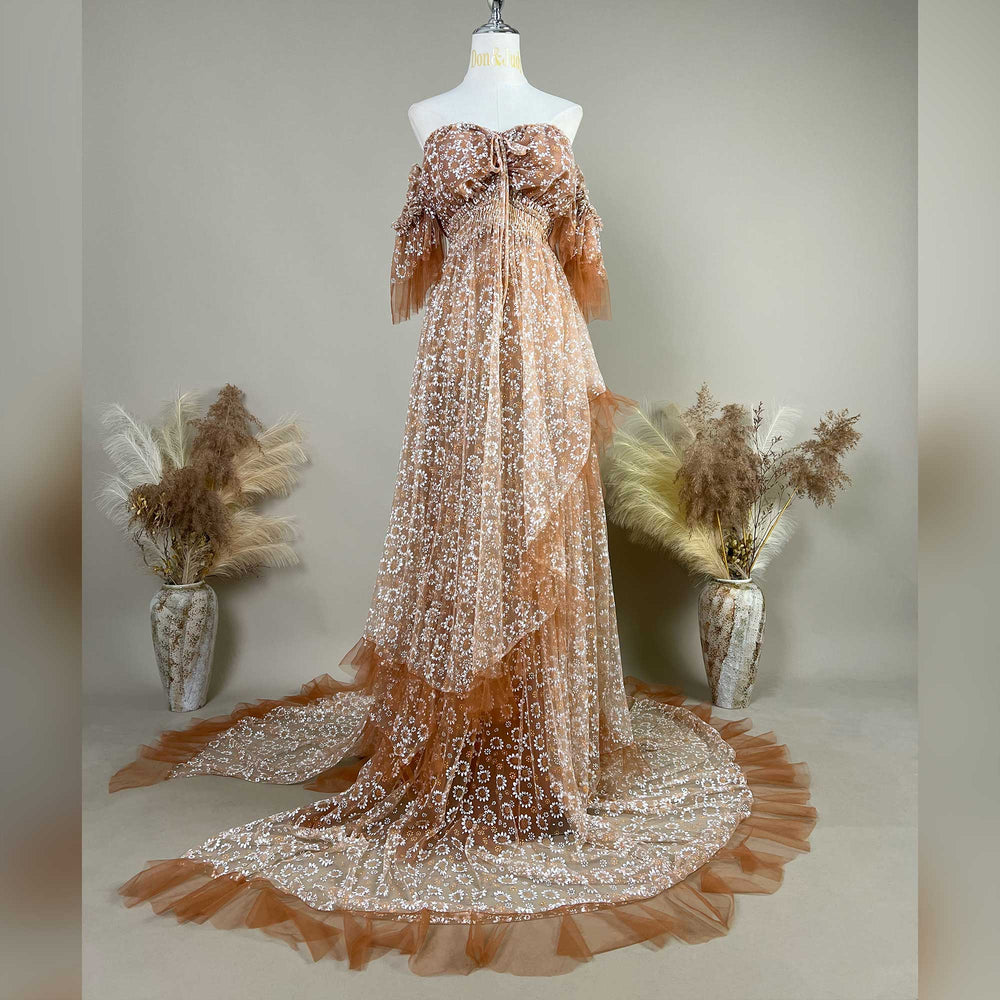 A Khaki Tyche gown with embroidery is displayed on a mannequin; the dress features a train and a ruffled hem structure.