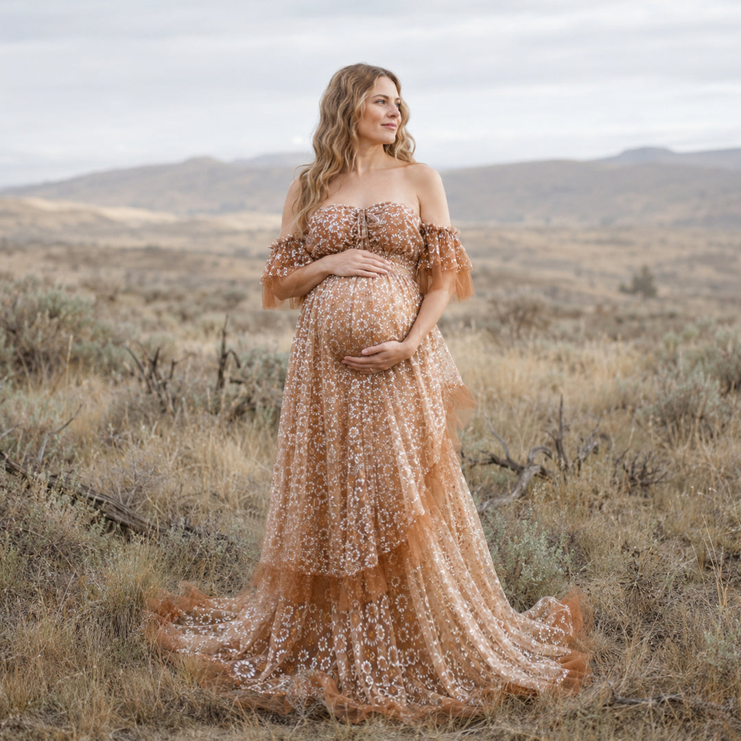 A woman is wearing a Tyche Khaki stands hills and dry vegetation.