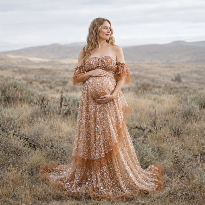 A woman is wearing a Tyche Khaki stands hills and dry vegetation.